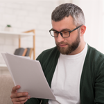 Concentrated man reading printed article, education at home
